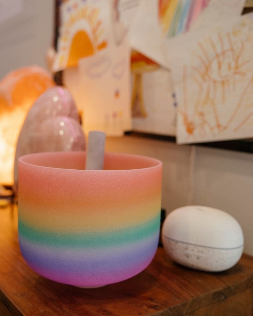 Rainbow crystal singing bowl in front of children's artwork at The Hub, Pediatric Reiki LV in Las Vegas